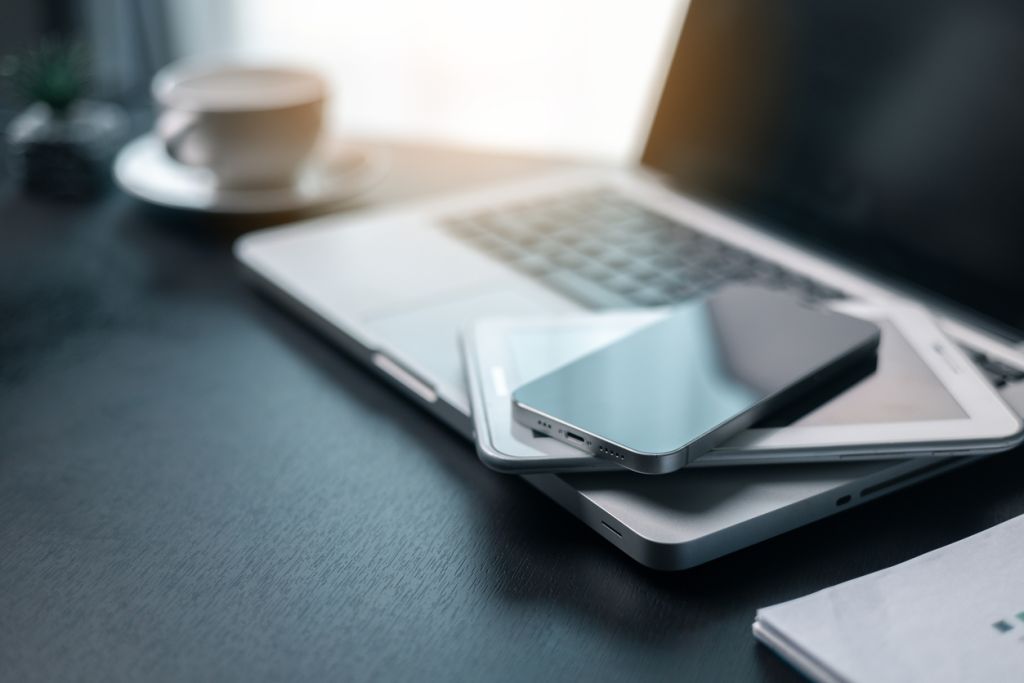 Office workplace with laptop and smart phone on wood table. Workspace, desktop computer, office supplies, houseplant and books at office. desk work concept. laptop Comfortable work table in office.